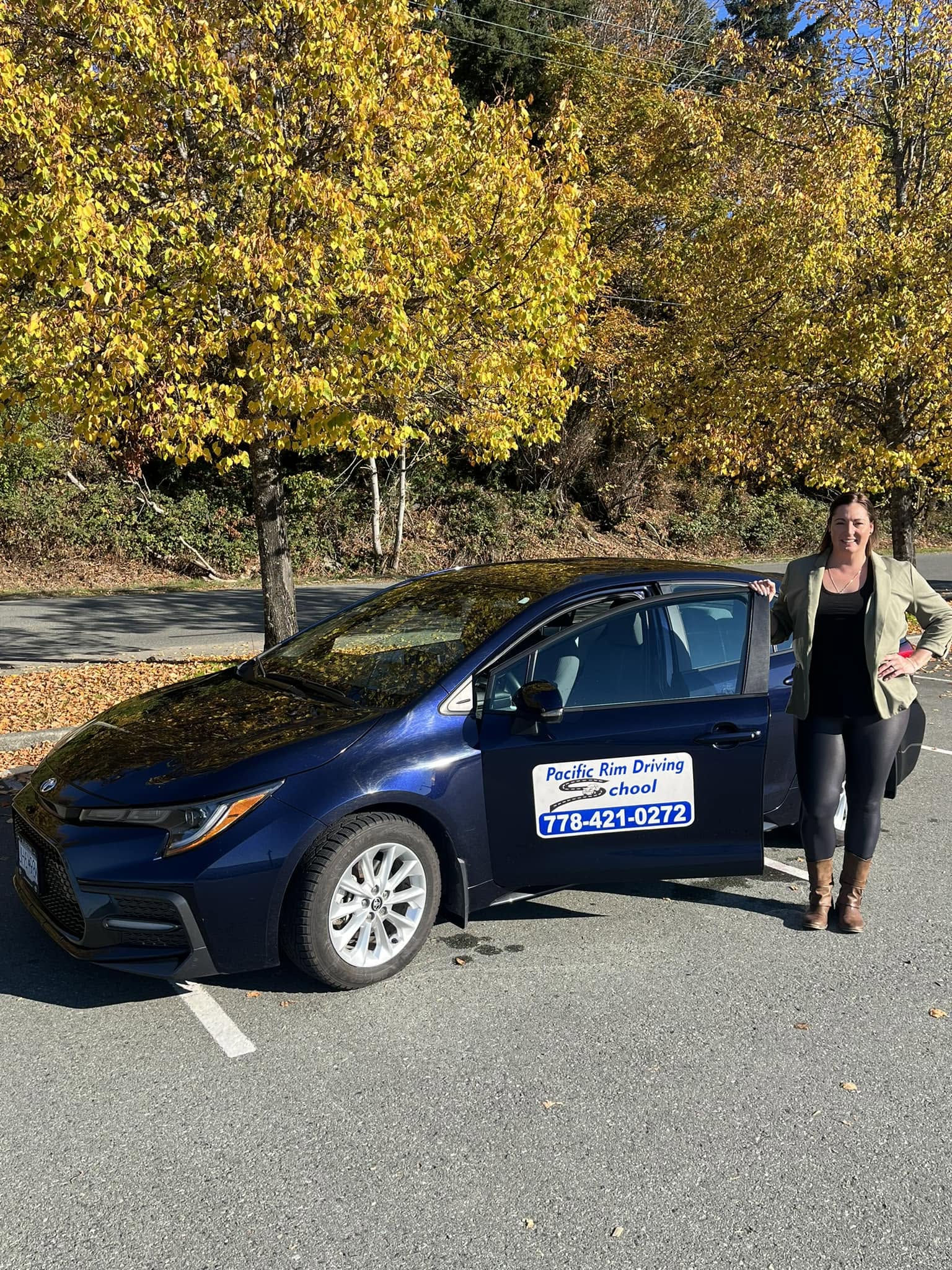 Jill Banman beside the Pacific Rim Driving School vehicle